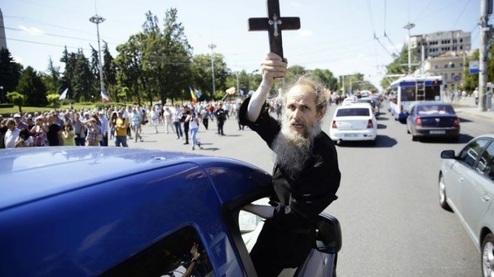 Apariție ciudată la protestul de duminică. Un bărbat cu barbă și haine de preot, a ieșit pe geamul unei mașini, cu o cruce și o icoană in mană, indreptandu-le spre manifestanti: “- Cu Rusia! Nu cu Europa voastra!"